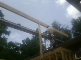 Carpenter setting a ridge beam over a new addition frame — Ice Dam Removal by Roofing Brothers in Duck Creek Village