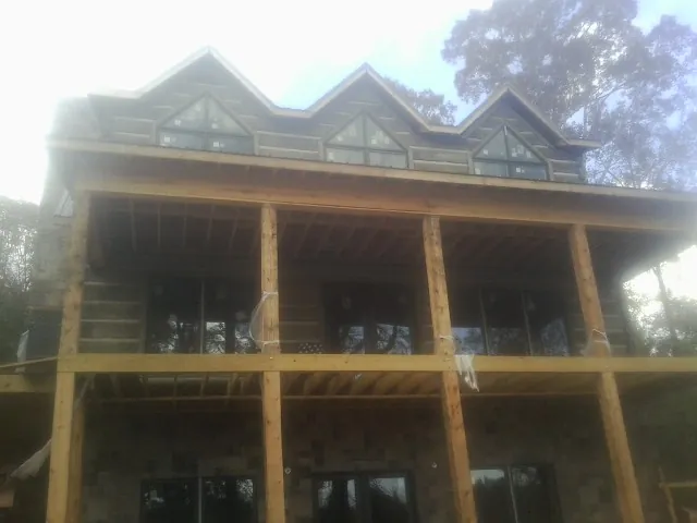 Dormers and porch framing on a large log home under construction — Roof Coating work by our crew in Duck Creek Village