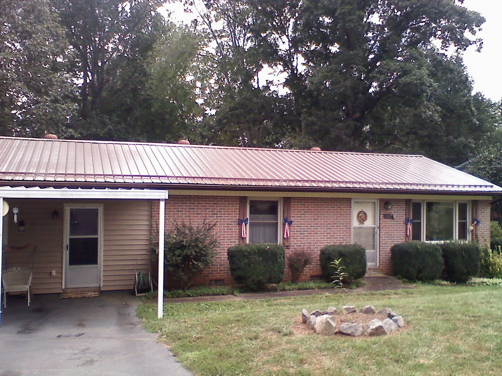 Bronze metal roof and carport on a brick ranch home — Roof Repair work by our crew in Duck Creek Village